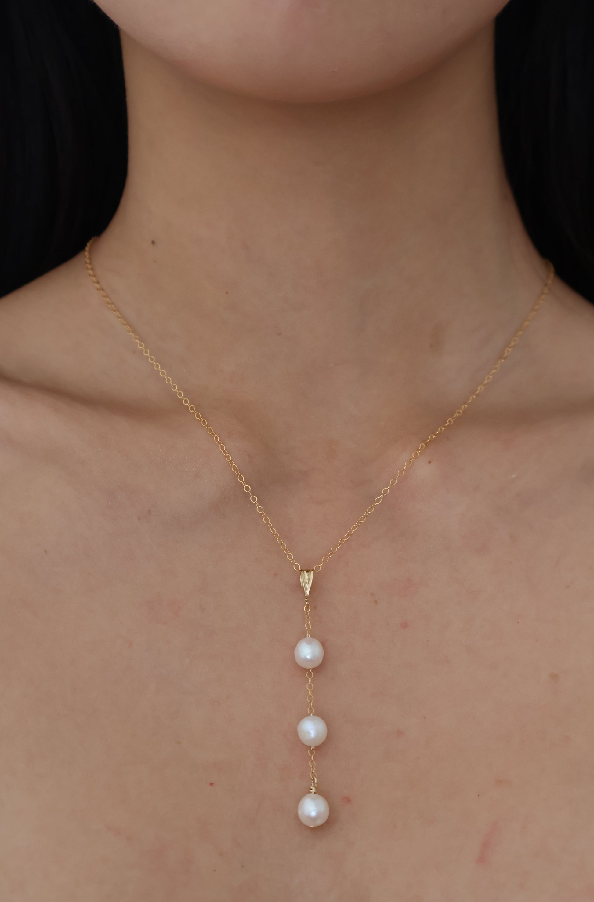 Gold necklace with pearls on a person's neck